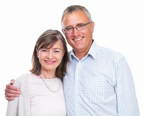 Two smiling adults standing together with one resting an arm around the other against a white background.